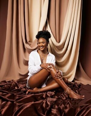 Lady wearing white top sitting on materials